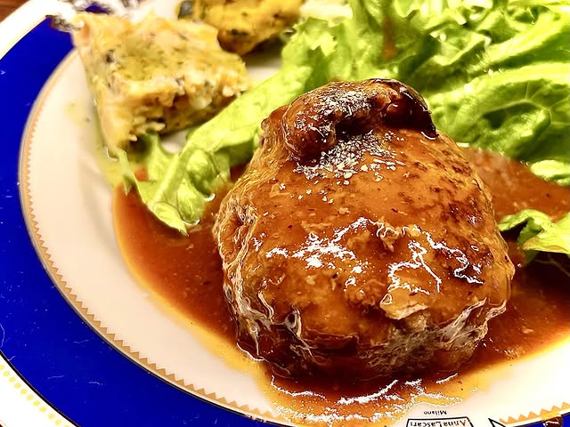 AseeKの煮込みハンバーグ。サラダと副菜を添えた一皿
